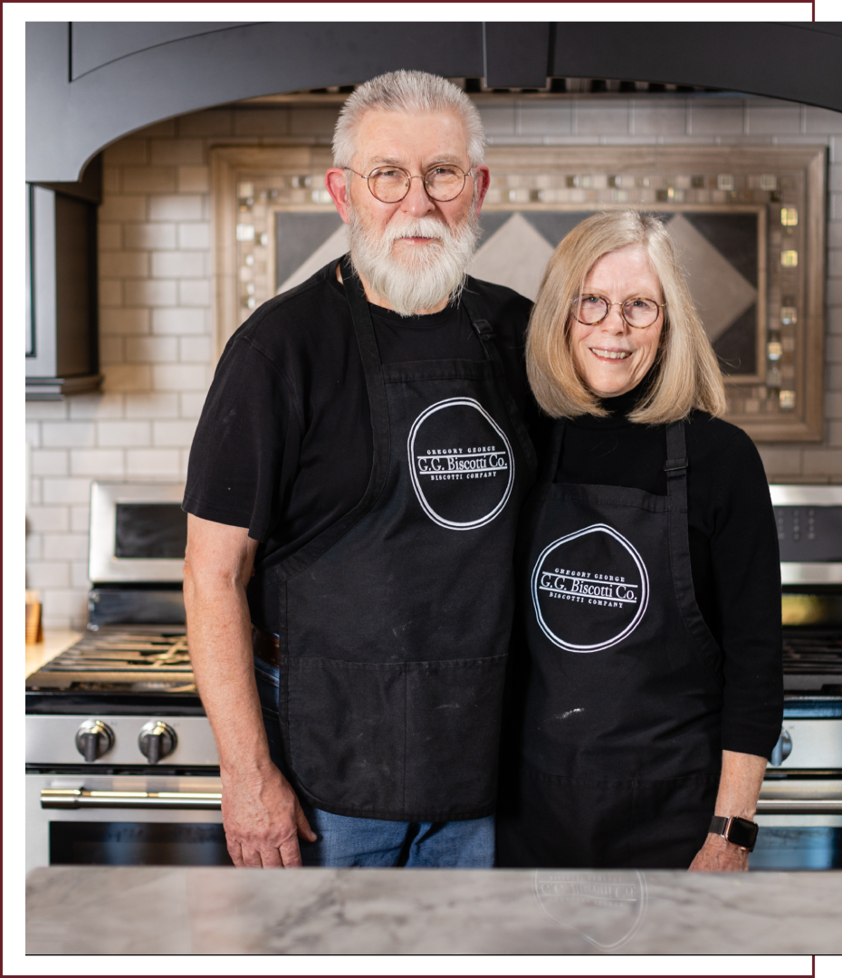 A man and woman wearing aprons in front of an oven.