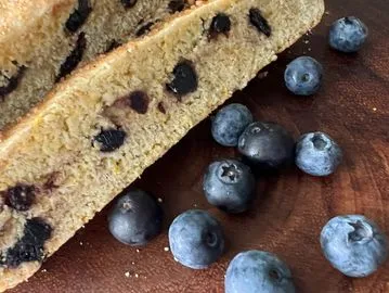 A close up of some blueberries and a piece of cake