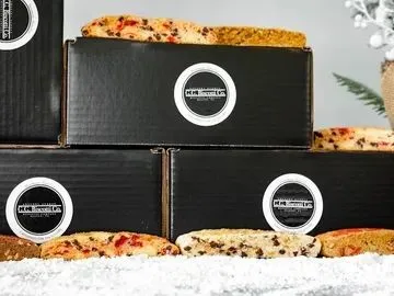 Three boxes of pizza sitting on top of a table.