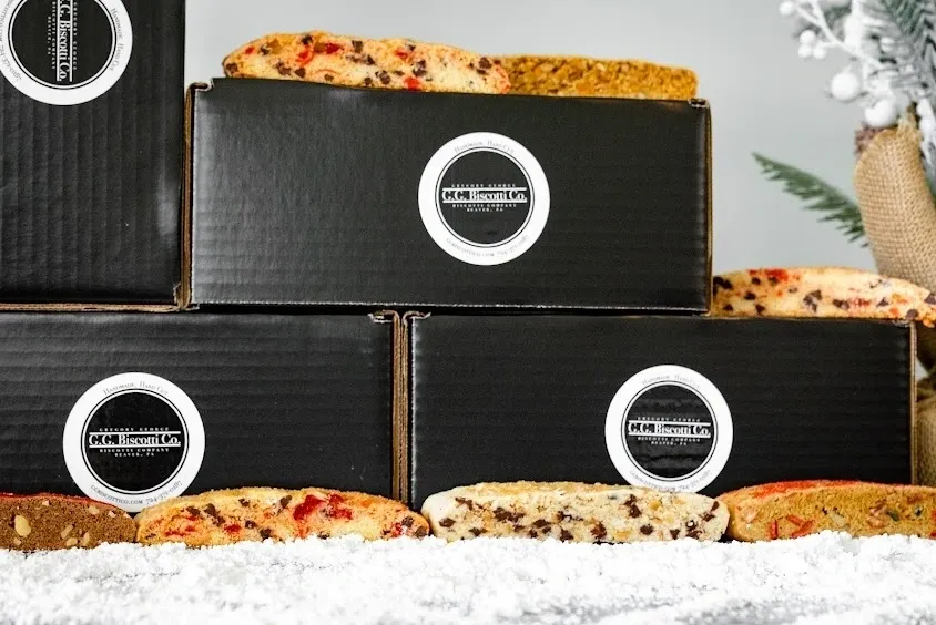 A stack of three boxes filled with different kinds of pizza.