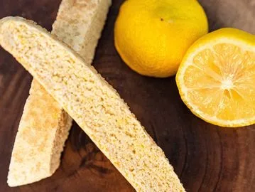 A wooden table with lemon and other food items.