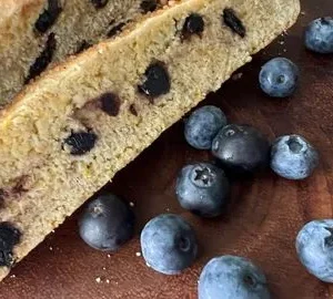 A close up of some blueberries and a piece of cake