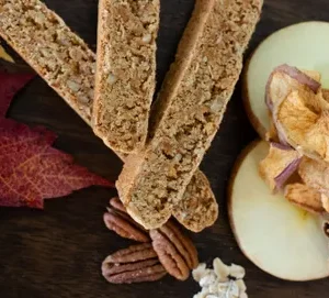 A table topped with slices of apple and nuts.