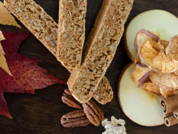 A table topped with slices of apple and nuts.