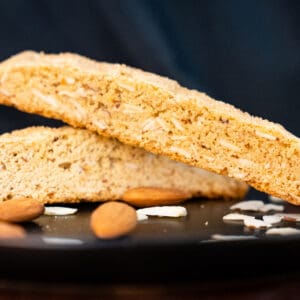G. G. Biscotti Co. artisan almond biscotti close up with whole almonds and sliced almonds sprinkled around the biscotti